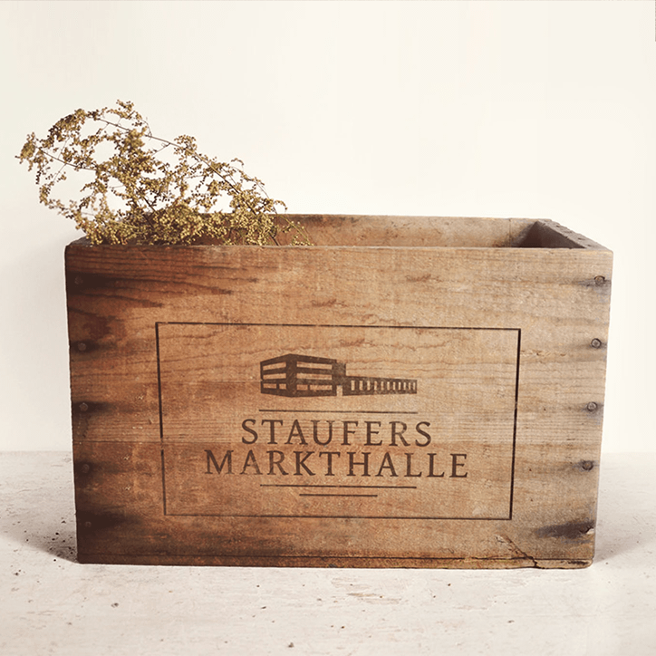 Holzkiste mit eingebranntem Logo der STAUFERS Markthalle in Göppingen
